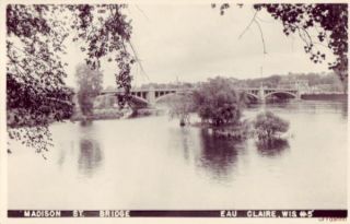  is an unused real photo postcard titled madison st bridge eau claire